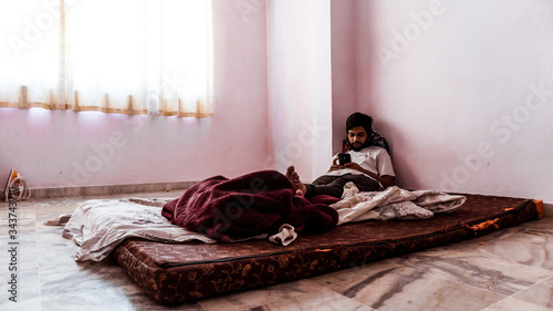 Young man doing timepass alone in the room beacuse for lockdown. photo