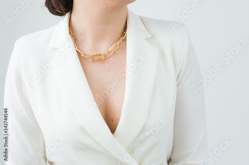 Close-up of woman wearing a gold necklace. Jewelry, bijouterie and accessories concept.