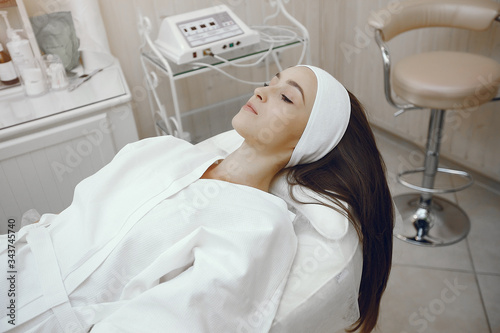 Cosmetology theme. Girl in a white bathrobe. Woman in a cosmetology studio.