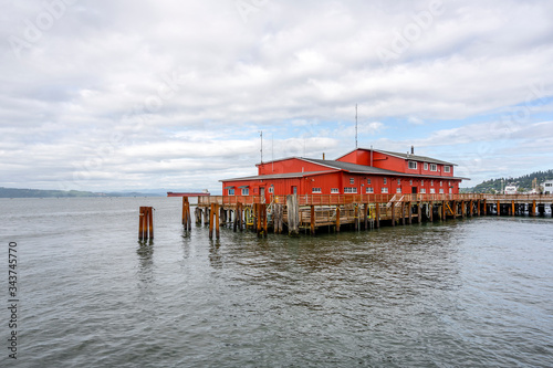 Old pier with wooden flooring and an administrative building for pilot ships in Astoria at the mouth of the Columbia River © vit