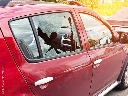 Broken glass on the passenger door of a passenger car parked. The concept of crime of car theft, theft of valuables.
