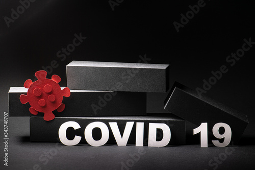 Foto Fallen economic bar chart with covid19 word and virus figure over black