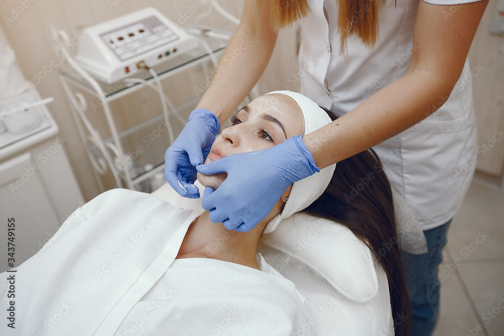 Cosmetologist treats client's skin. Woman with cosmetologist. Lady in a beauty studio.