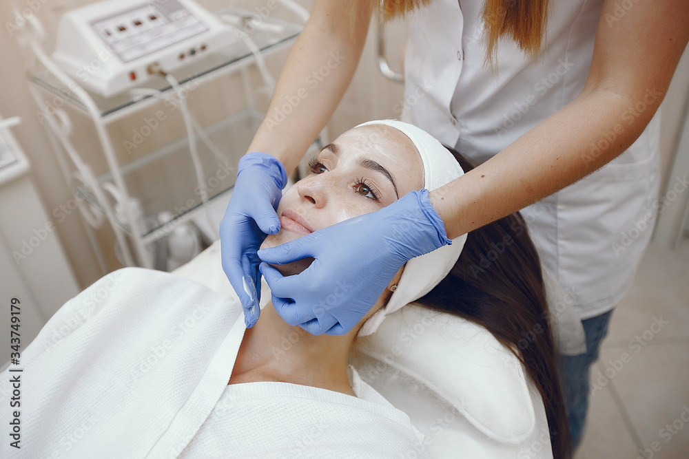 Cosmetologist treats client's skin. Woman with cosmetologist. Lady in a beauty studio.
