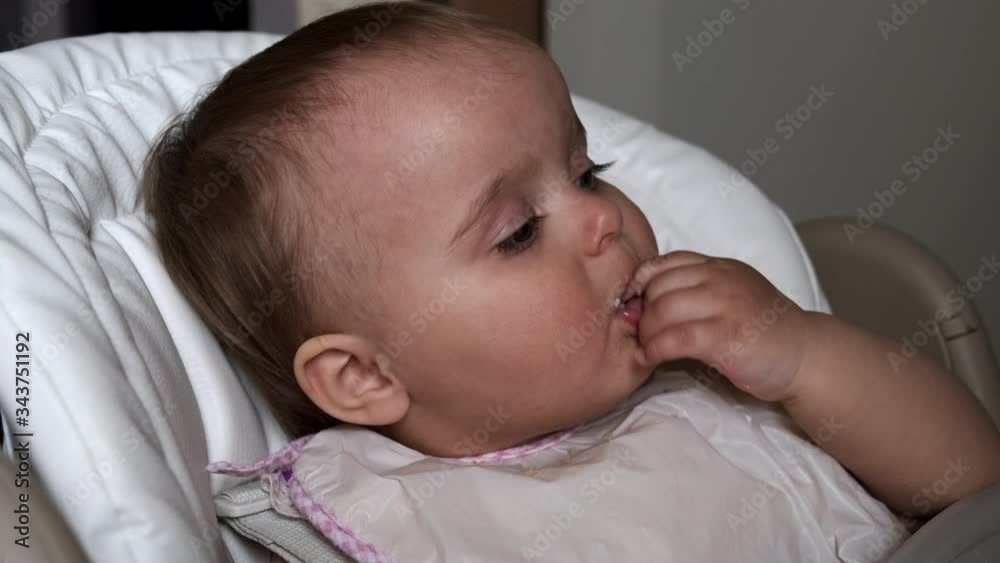 A little funny girl eats bread crumbs with hands. A little funny girl eats bread crumbs with hands.