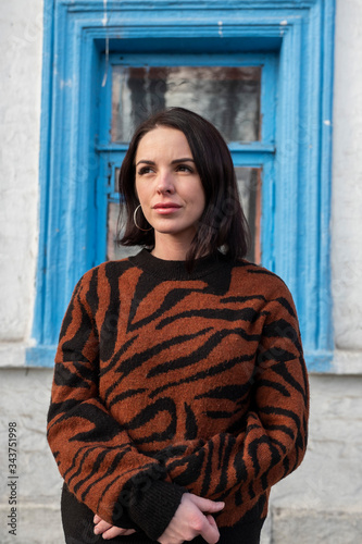 woman on the background of the window. brunette outside a residential building