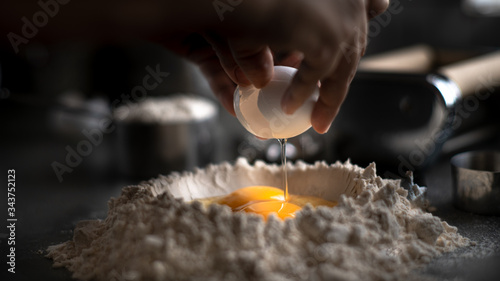 Process of making homemade wholewheat pasta in a kitchen with pasta sheet roller. Close up view. Dark photography