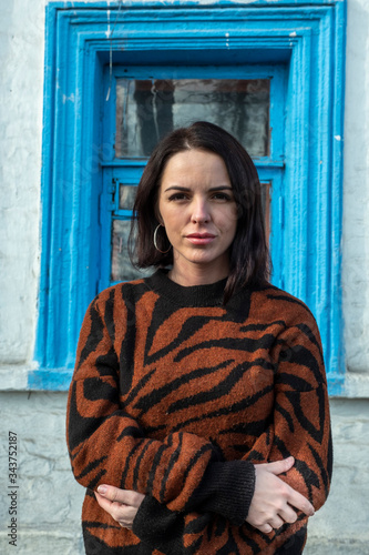 woman on the background of the window. brunette outside a residential building