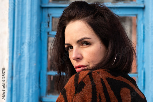woman on the background of the window. brunette outside a residential building