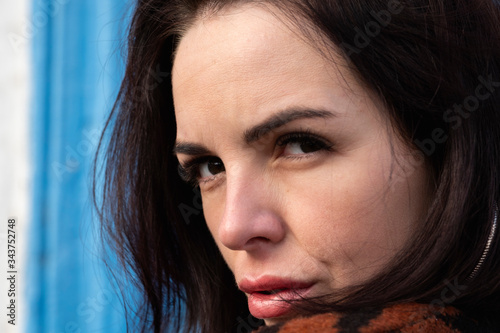 woman on the background of the window. brunette outside a residential building