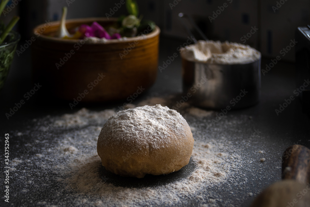 Process of making homemade wholewheat pasta in a kitchen with pasta sheet roller. Close up view. Dark photography