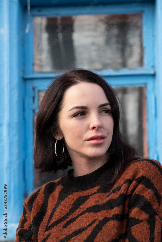 Fototapeta premium woman on the background of the window. brunette outside a residential building