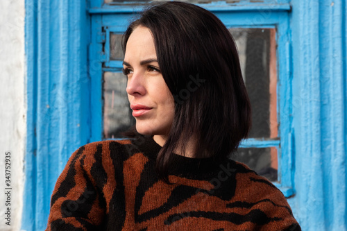 woman on the background of the window. brunette outside a residential building