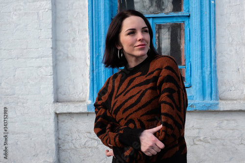 woman on the background of the window. brunette outside a residential building