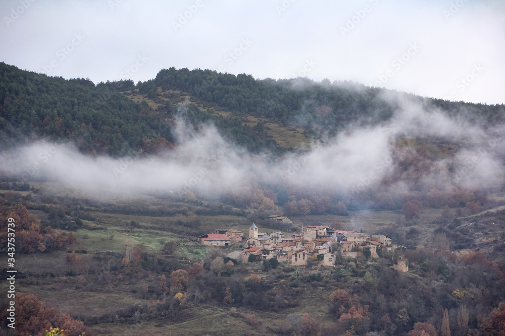 Small village in the middle of the mountain with vegetation and clouds on a cold day Small village in the middle of the mountain with vegetation and clouds on a cold day