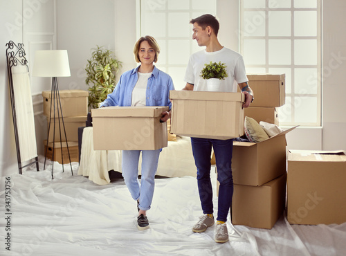 Couple holding boxes for moving the hands and looking inside box