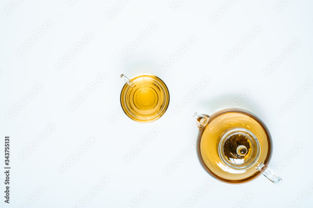 glass teapot and cups with hot tea on table, top view glass teapot and cups with hot tea on table, top view