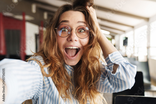 Image of funny beautiful woman expressing surprise and taking selfie