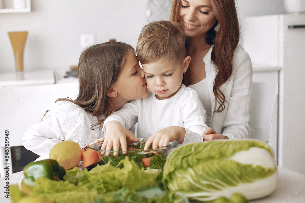 Family in a kitchen. Beautiful mother with children. Lady in white blouse. Family in a kitchen. Beautiful mother with children. Lady in white blouse.