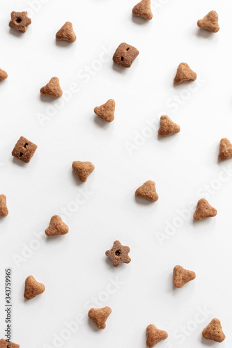 Background of cat dry food. Minimalistic white flat. Domestic kitty care. Natural backdrop