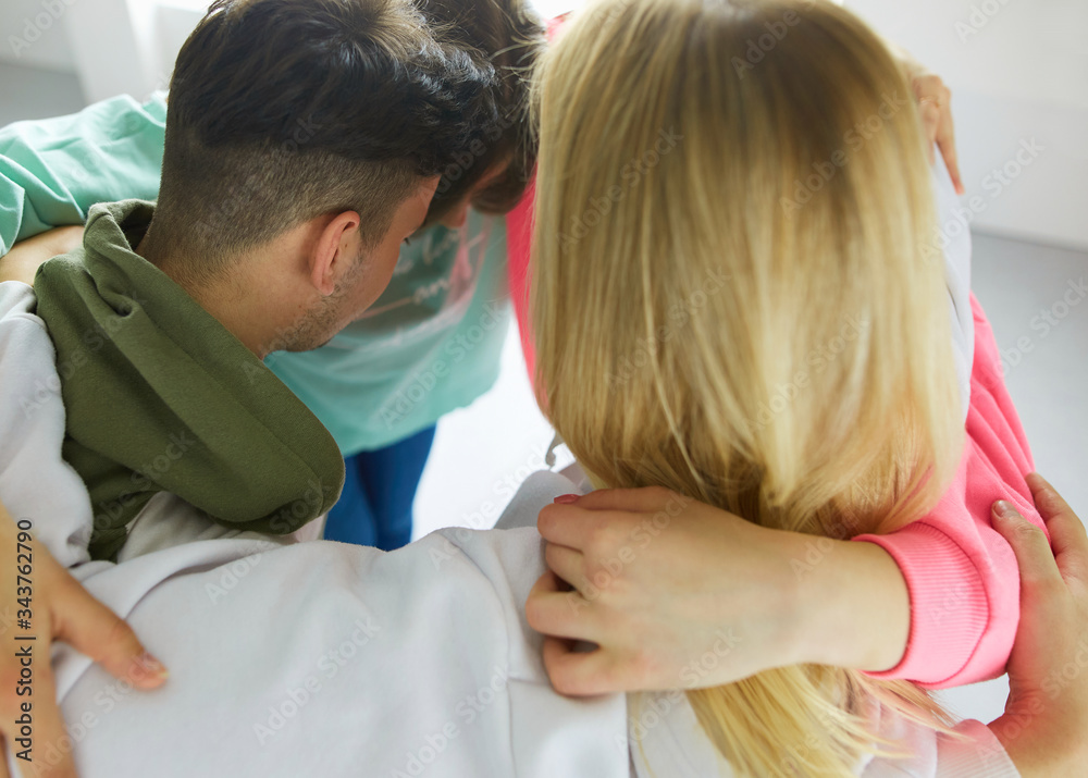 Fototapeta premium Happy smiling friends, group of young people standing and embracing together