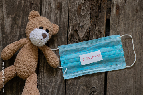 baby brown teddy bear and medical mask during a pandemic, childhood diseases photo