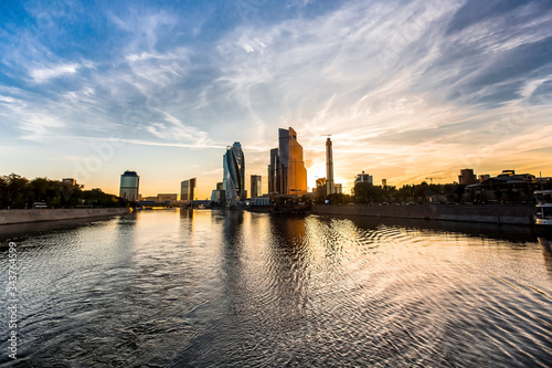 Sunset over the river with reflection of modern buildings. Moscow city above the water