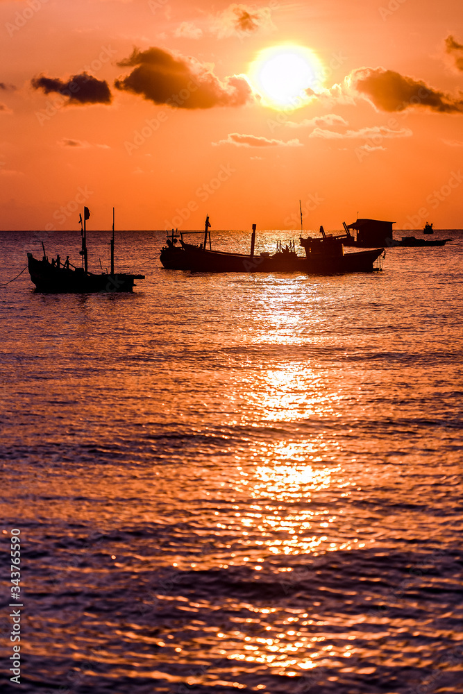 Sunset on the beach. Sea, ships and orange sky