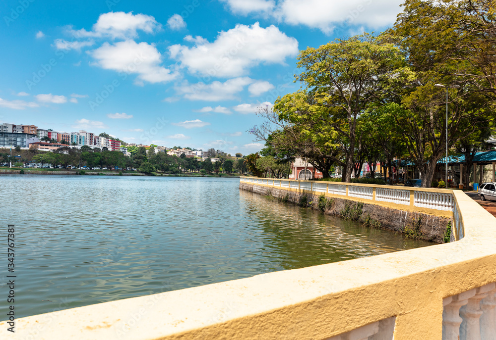 Park with tree and pond on sunny day and blue sky in Brazilian winter. Famous lake in the touristic city of Bragança Paulista, state of Sao Paulo, Brazil.