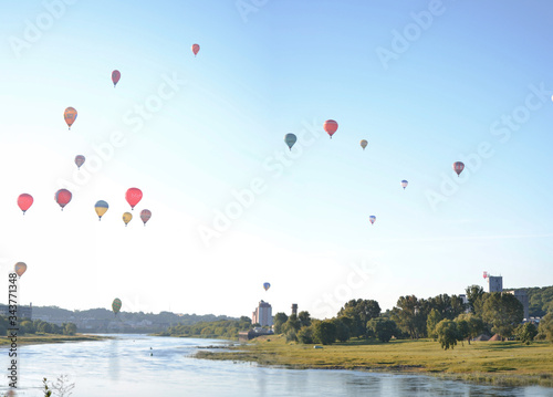 Fotografie, Obraz Hot Air Balloons Flying Over Lake Against Sky