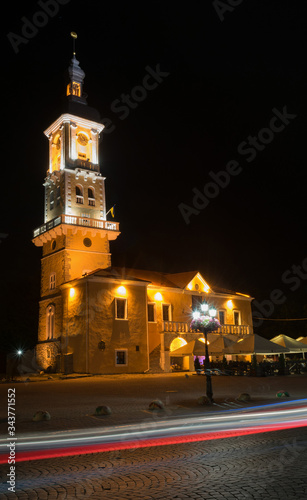 Night illumination of the bell tower near the road in the old city