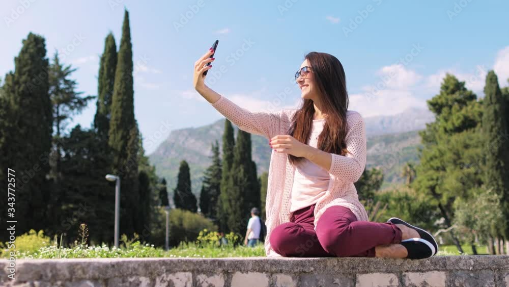 woman making selfie photo on phone camera outdoors. Long hair woman taking selfie photo on phone and smiling close up. woman making selfie photo on phone camera outdoors. Long hair woman taking selfie photo on phone and smiling close up.