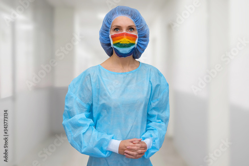 Portrait of a doctor in a mask, on which a rainbow is drawn as a sign of hope of victory over a coronovirus infection photo