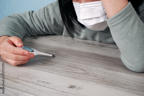 Child measuring body temperature with a thermometer.  体温計で体温をはかる子供