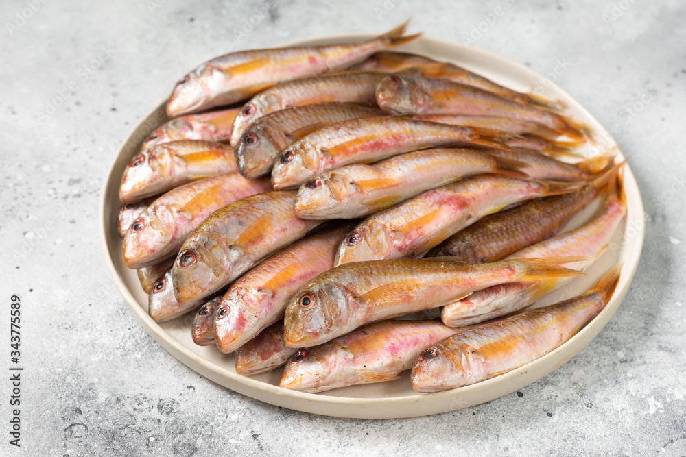 Black sea barabulka fish in a white ceramic bowl on a light gray kitchen table. A lot of fish red mullet. Black sea barabulka Black sea barabulka fish in a white ceramic bowl on a light gray kitchen table. A lot of fish red mullet. Black sea barabulka