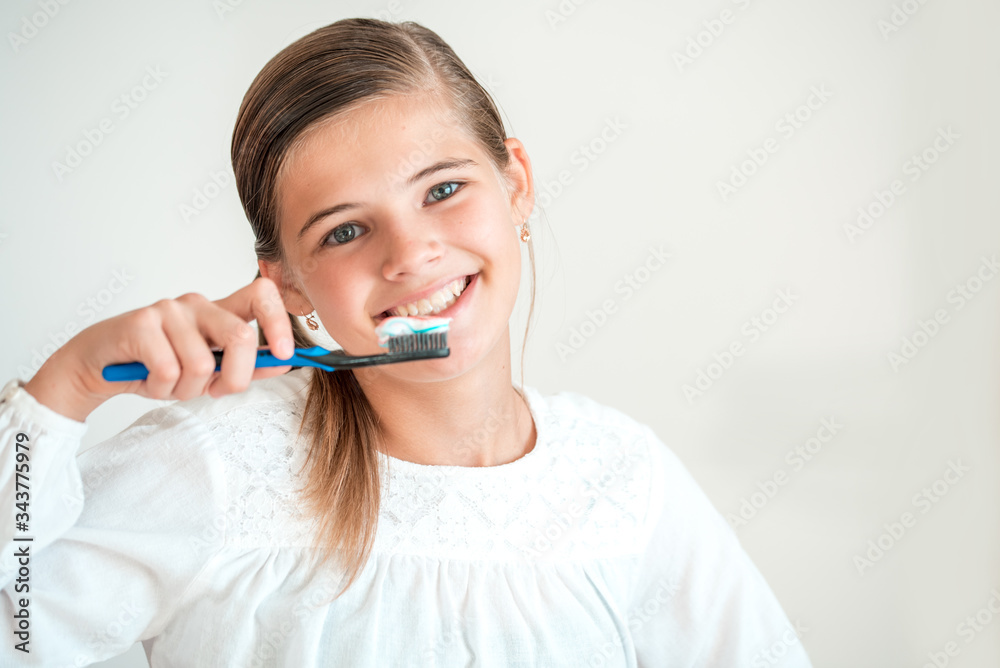 Happy Young Teen girl Brushing her Teeth.Healthy beautiful teeth. happy smile. on white background Happy Young Teen girl Brushing her Teeth.Healthy beautiful teeth. happy smile. on white background