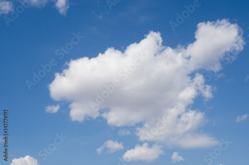 Blue sky and a huge white cloud. Summer sunny day. Background.