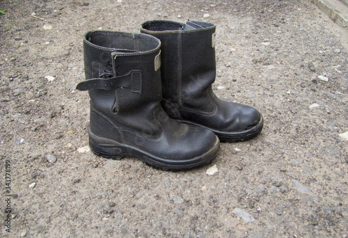 Black kirz men's boots that stand on the track. Side view