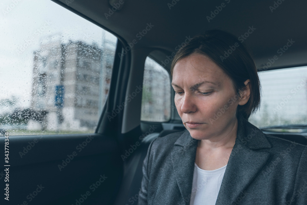 Worried businesswoman sitting at car back seat Worried businesswoman sitting at car back seat