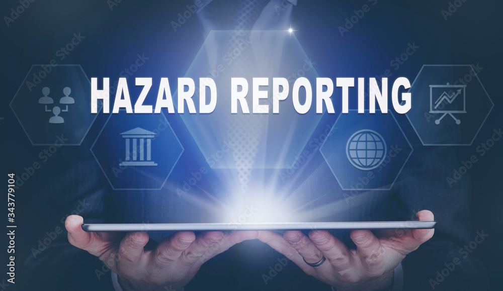 Fototapeta premium Businessman holding a computer tablet display projecting a Hazard Reporting concept.