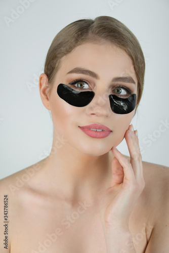 Under Eye Skin Black Patch. Closeup Of Beautiful Young Woman Face With Moisturizing Collagen Mask Pad On Healthy Fresh Facial Skin On White Background