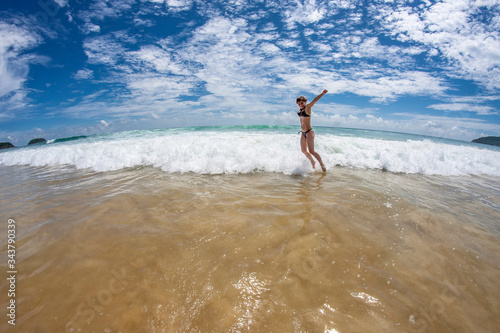 Girl jumping in a wave on the beach