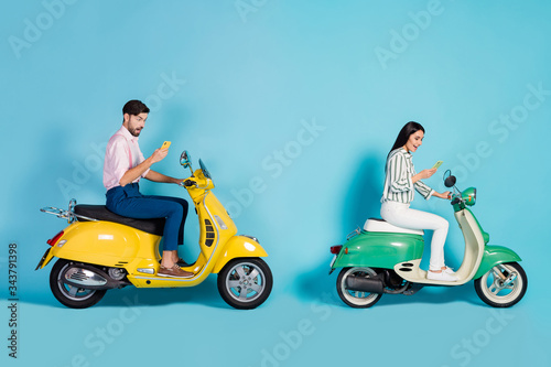 Full body profile side photo shocked crazy man woman drive yellow green choppers use smartphone search journey destination impressed wear formalwear outfit isolated blue color background