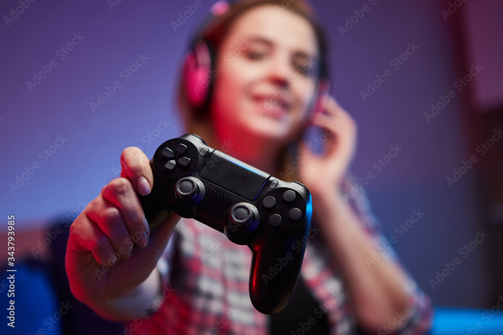 Portrait of crazy playful Gamer enjoying Playing Video Games on Playstation indoors sitting on the sofa, holding Console Gamepad in hands, Xbox fans. Resting At Home, have a great Weekend Portrait of crazy playful Gamer enjoying Playing Video Games on Playstation indoors sitting on the sofa, holding Console Gamepad in hands, Xbox fans. Resting At Home, have a great Weekend