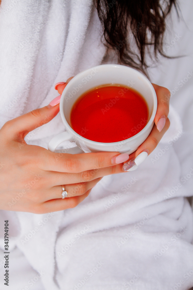 Cup of tea in female hands. Photo with cup of red tea.
