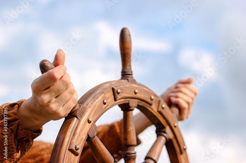 Foto Steering hand wheel ship on sky background, hand hold hand wheel