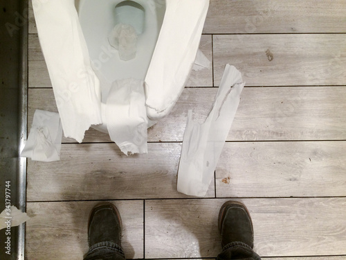 messy public restroom with toliet paper all over photo