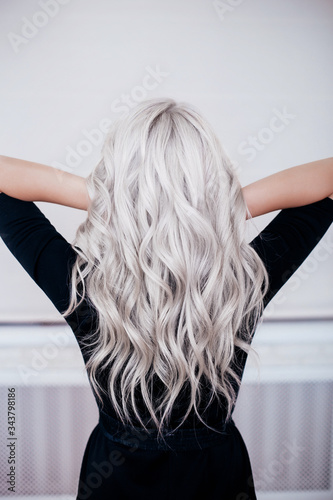 Female back with silver grey ash blonde curly wavy long hair in black dress  photo