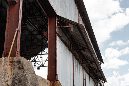 View inside an industrial warehouse, corrugated metal siding, concrete bases with metal i-beams, horizontal aspect photo