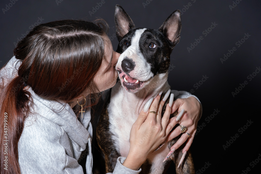 Obraz premium young woman with her pet in confinement, bull terrier bitch